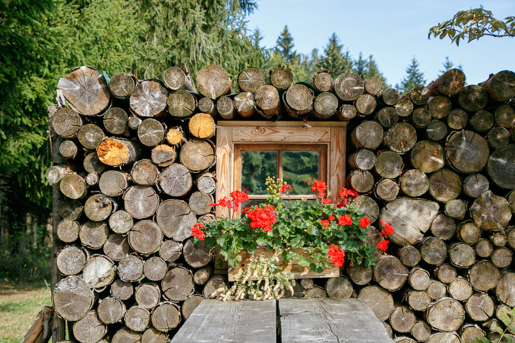 Fenster im Holzstapel auf der Dichtlalm